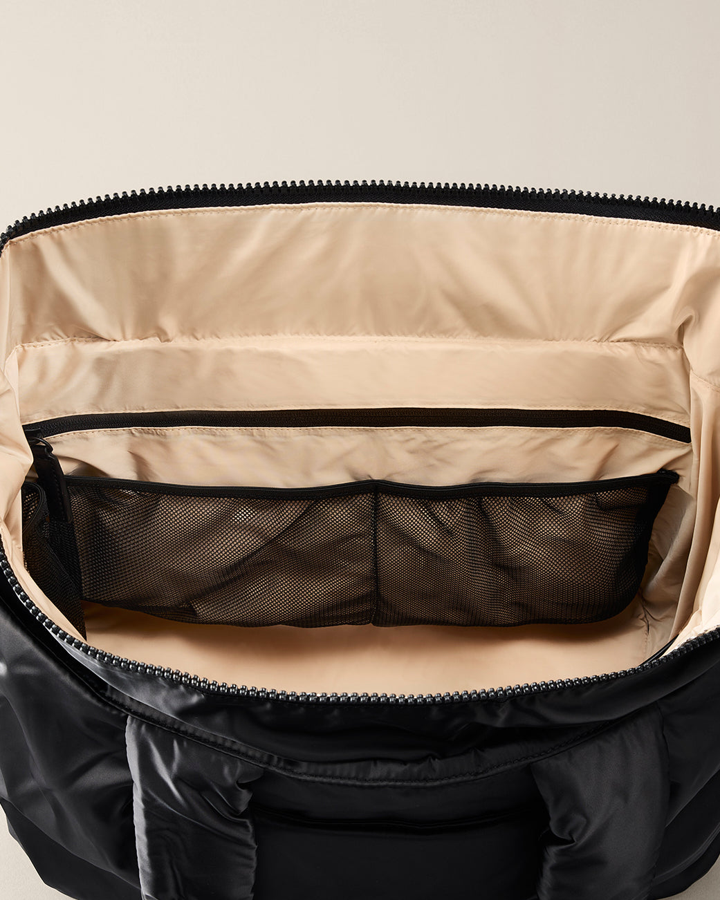 Open black TYVY Aviator Tote bag optimized for travel. with beige interior showing compartments.