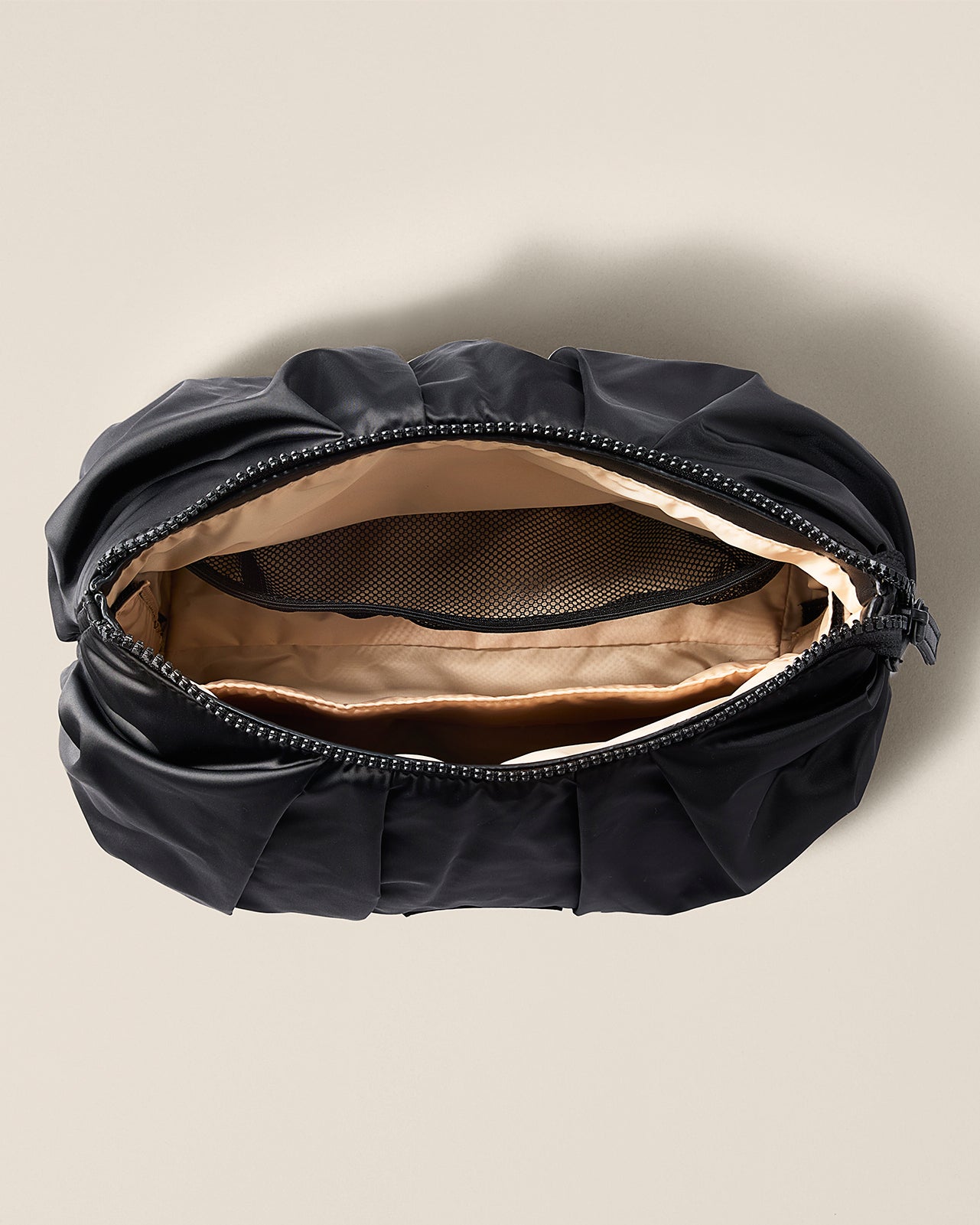 Black clutch bag with beige interior on a beige background TYVY Carry All pouch
