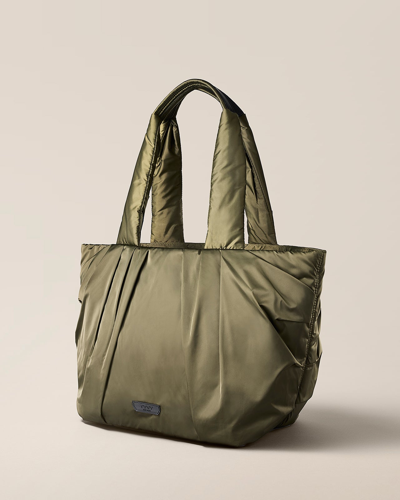Olive Green tote bag on a beige background. TYVY Aviator Tote bag optimized for travel.