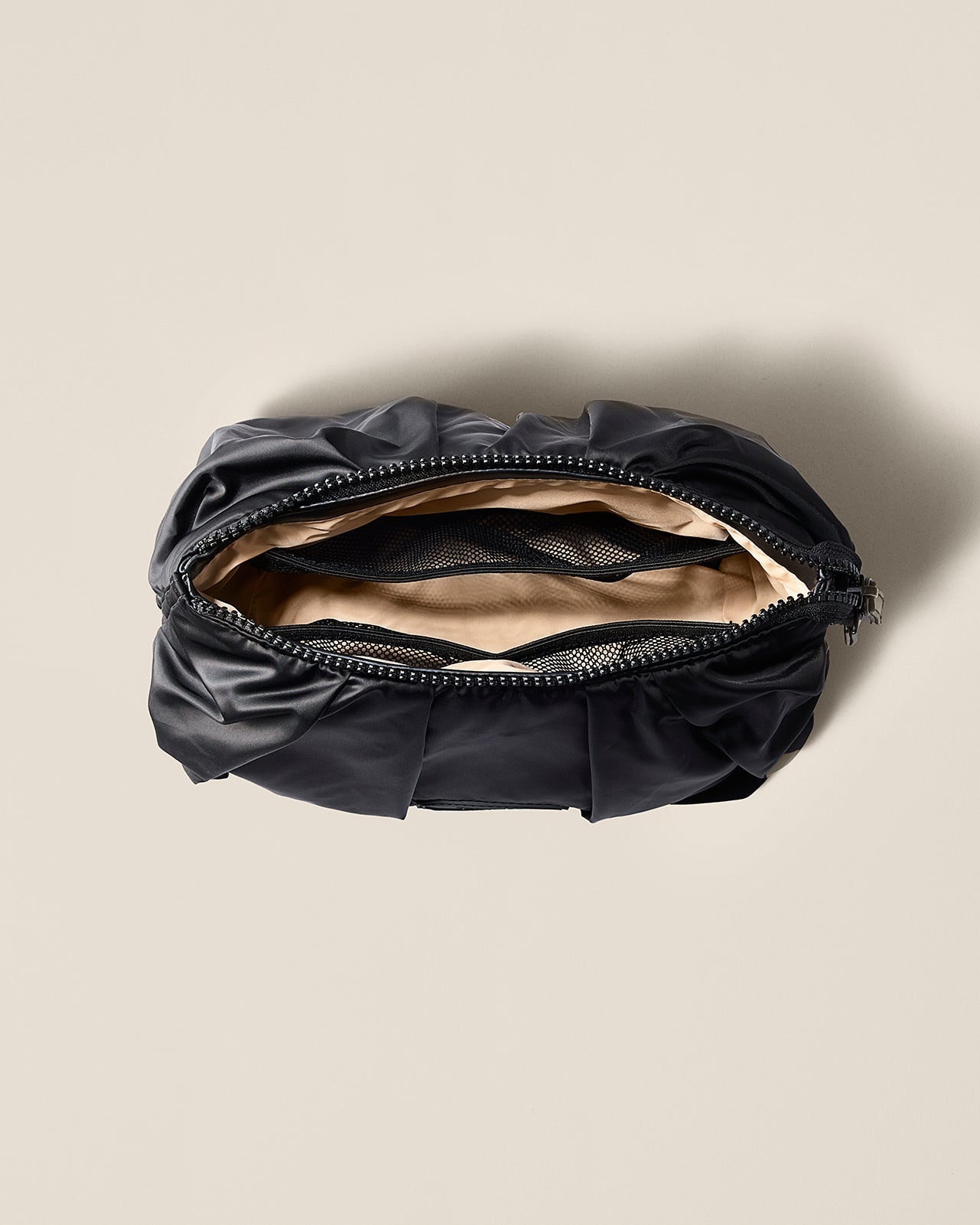 Black bag with a beige interior on a beige background TYVY Carry All pouch