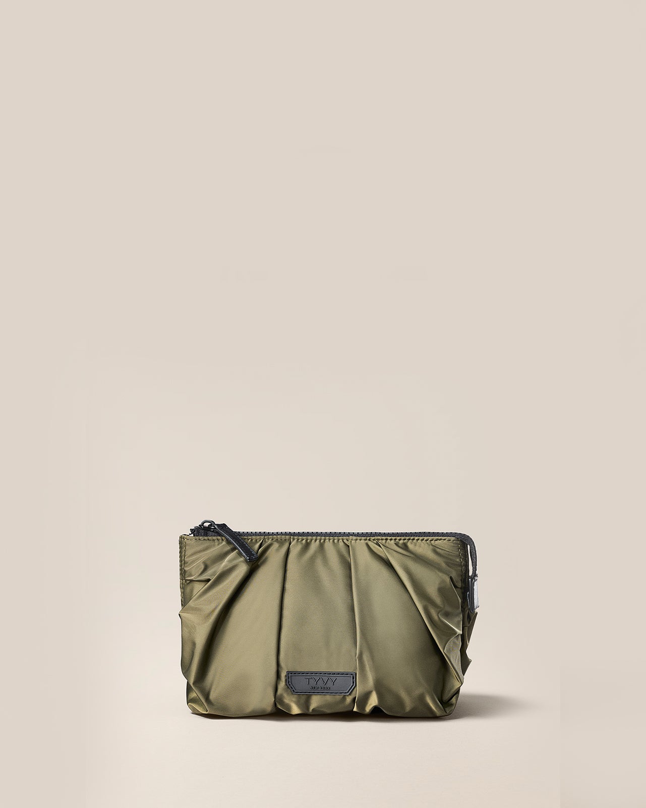Green pouch with a brand label on a beige background of TYVY Aviator Carry all pouch.