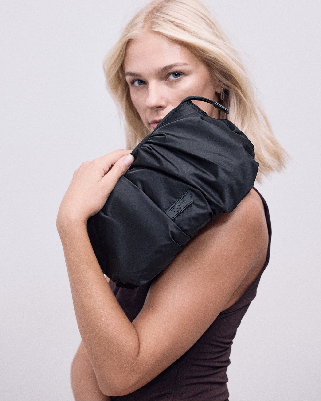 A woman holding the black TYVY carry all bag.